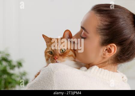 Belle femme avec chat mignon à la maison Banque D'Images