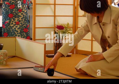 Une jeune femme japonaise participe à la cérémonie traditionnelle du thé intemporelle dans une maison murale en papier au Japon Banque D'Images