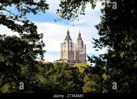 Les tours des appartements San Remo de New York, encadrées par les arbres dans Central Park contre un ciel bleu avec des nuages. Banque D'Images