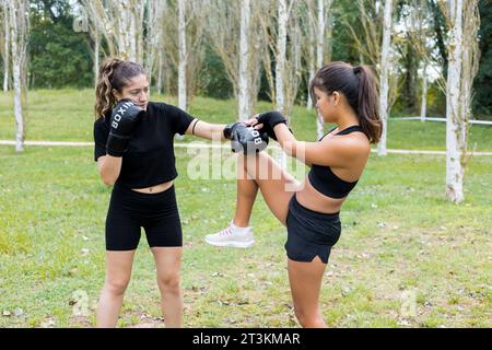 Deux jeunes boxeuses multiethniques s'entraînant en plein air. Entraînement de boxe et de kick. Banque D'Images