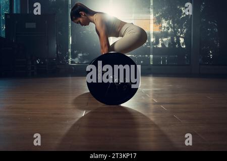 Jeune femme faisant l'exercice de soulevé de terre à la salle de gym. Banque D'Images