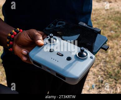 Homme utilisant un drone avec télécommande avec un téléphone portable attaché Banque D'Images
