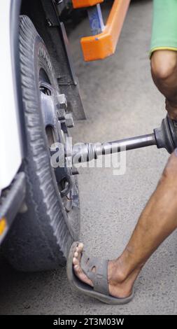 poser les écrous sur les roues du chariot à l'aide d'outils mécaniques. Banque D'Images