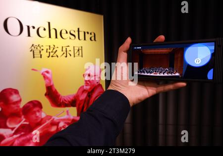 Tianjin. 25 octobre 2023. Un visiteur regarde la performance d'un orchestre à travers un dispositif interactif à l'exposition Juilliard imagination organisée par l'école Juilliard de Tianjin dans le nord de la Chine, Tianjin, le 25 octobre 2023. L'exposition Juilliard imagination offre aux visiteurs une riche exposition de musique, de danse et de théâtre à travers des expériences interactives audio et visuelles. Crédit : Sun Fanyue/Xinhua/Alamy Live News Banque D'Images