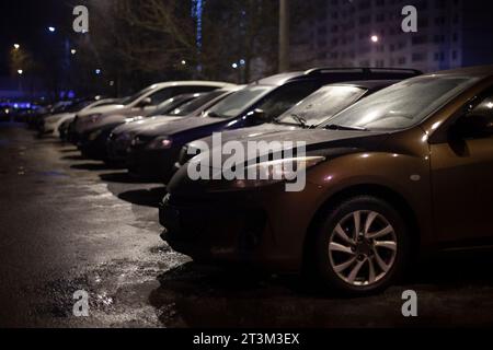 Voiture dans le parking la nuit. Les véhicules sont garés dans la cour. Les voitures sont garées dans la rue la nuit. Voiture dans l'obscurité. Banque D'Images