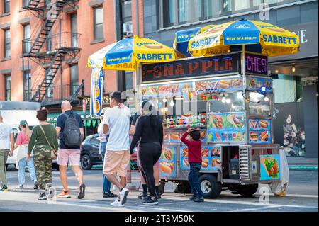 Camion repas halal coloré avec parapluies sur le trottoir de Manhattan Banque D'Images