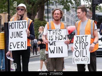 Londres, Royaume-Uni. 19 juillet 2023. Just Stop Oil militants brandissent des pancartes de protestation sur la place du Parlement, faisant campagne pour que le gouvernement arrête toute licence et production future de combustibles fossiles. Banque D'Images