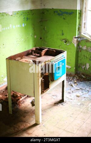 Poêle en fonte rouillé et endommagé dans un bâtiment abandonné. Banque D'Images