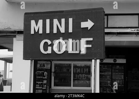 Panneau Mini Golf noir et blanc pointant vers la direction où le jeu de sport d'attraction est joué Banque D'Images