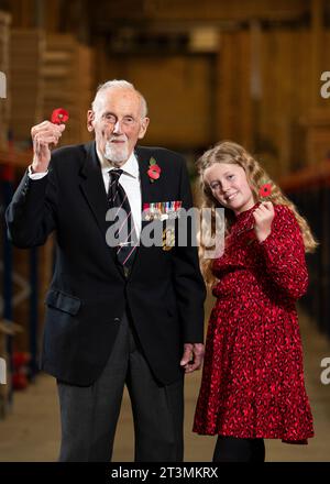 John Roberts, vétéran du jour J de 99 ans, qui a servi dans la Royal Navy pendant 40 ans, et Maisie Mead, 12 ans, collectionneuse de Poppy Appeal de Plymouth, tenant le nouveau coquelicot en papier sans plastique, la première refonte du coquelicot depuis 28 ans, à l'entrepôt Poppy Appeal de la Royal British Legion à Aylesford, pour le lancement de la Royal British Legion Poppy Appeal 2023. Date de la photo : jeudi 26 octobre 2023. Banque D'Images