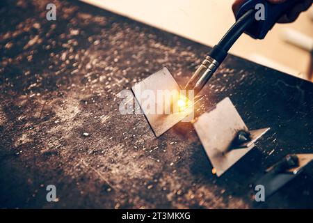 Le soudeur TIG tient la torche de soudage d'une machine à souder et soud l'acier inoxydable Banque D'Images