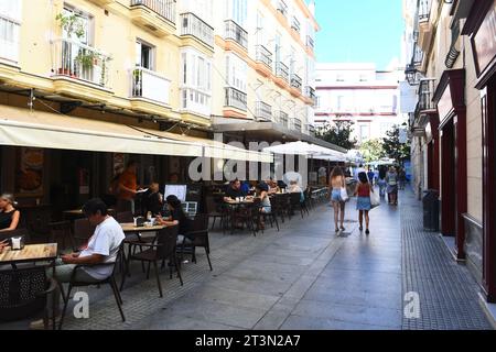 Les piétons marchent le long de la passerelle désignée, les habitants et les touristes s'assoient dans les restaurants de trottoir à Cadix Espagne 03 août 2023 Banque D'Images