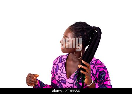 belle jeune femme portant un lointain traditionnel et tenant ses cheveux tressés tout en souriant. Banque D'Images