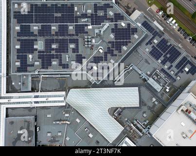 26 octobre 2023, Saxe, Leipzig : des panneaux solaires sont sur le toit du Centre Paunsdorf. Selon l’opérateur, le plus grand système photovoltaïque sur le toit d’un centre commercial en Allemagne a été inauguré le même jour. Avec près de 2700 000 modules, 1,1 millions de kilowattheures d'électricité seront produites annuellement à l'avenir. L'usine marquera le début de l'autosuffisance du centre commercial en énergies renouvelables. L'objectif est de réduire les émissions de CO2 de 50 pour cent d'ici 2030 par rapport à 2015, a-t-il déclaré. (Vue aérienne avec drone) photo : Jan Woitas/dpa Banque D'Images