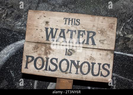 Panneau en bois avec une écriture indiquant que cette eau est toxique. Banque D'Images