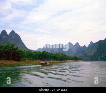 Chine. Province de Guangxi. Montagnes Yuecheng. Vue sur la rivière Li et bateau. Banque D'Images