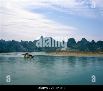 Chine. Province de Guangxi. Montagnes Yuecheng. Vue sur la rivière Li et bateau. Banque D'Images
