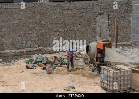 Santa Maria, île de Sal - Cap-Vert, 02 octobre 2023 : un homme en robe de travail dans une bétonnière lui fait travailler Banque D'Images