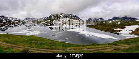 Montagnes avec de la neige, se reflétant dans un lac calme avec de grandes formations de glace sur Haukelifjell en Norvège Banque D'Images