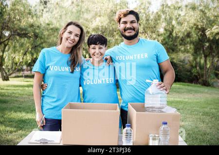 Équipe multiraciale de bénévoles travaillant à la collecte de biens et de nourriture pour le service communautaire à l'extérieur - dons et concept de projet de charité Banque D'Images