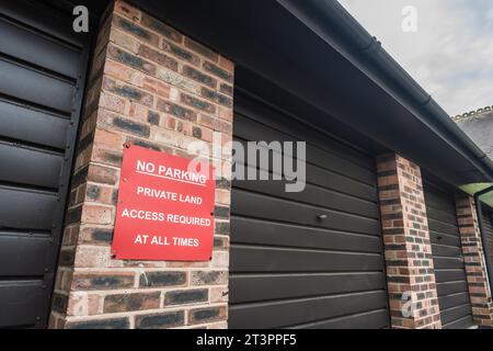 Nantwich, Cheshire, Angleterre, 17 juillet 2023. Gros plan d'un rouge sans parking, terrain privé avec accès requis en tout temps signe sur le garage. Banque D'Images