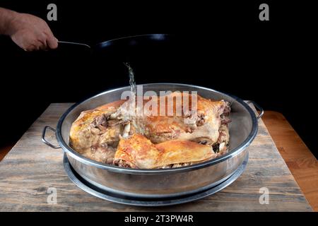 Cuisine turque agneau entier pour rôtir. Un agneau rôti entier dans une grande casserole attend d'être servi. Agneau entier rôti sur charbon de bois. Banque D'Images