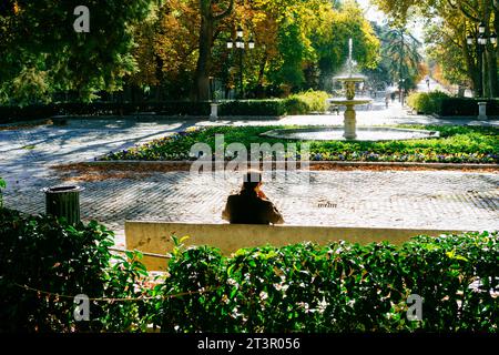 Homme assis devant une fontaine. Le parc Buen Retiro - Parque del Buen Retiro, littéralement «Parc de la retraite agréable», parc du Retiro ou tout simplement El Banque D'Images