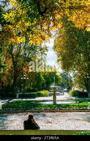 Homme assis devant une fontaine. Le parc Buen Retiro - Parque del Buen Retiro, littéralement «Parc de la retraite agréable», parc du Retiro ou tout simplement El Banque D'Images