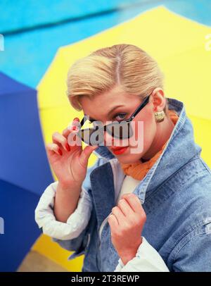 Portrait extérieur de jeune femme portant des lunettes de soleil. Banque D'Images