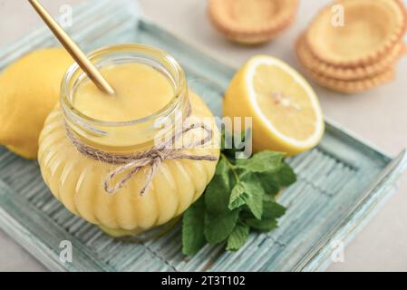 Caillé de citron maison dans un bocal en verre avec des citrons frais sur un plateau en bois closeup Banque D'Images
