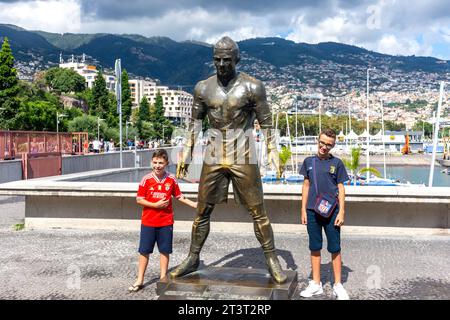 Garçons posant par la statue de Cristiano Ronaldo devant CR7 Musée Cristiano Ronaldo, Avenue Sá Carneiro, Funchal, Madère, Portugal Banque D'Images