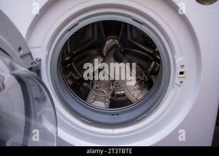 Vieilles baskets sales attendant d'être lavées dans la machine à laver Banque D'Images