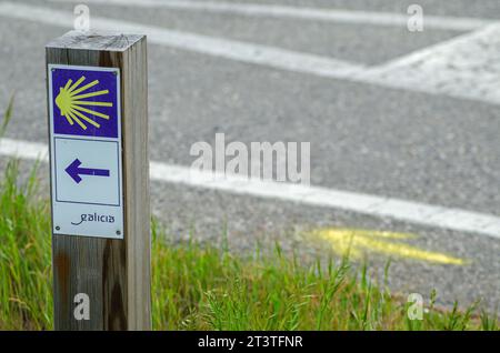 Panneau indiquant le Camino de Santiago en Galice et flèche jaune peinte au sol. Concept de pèlerinage Banque D'Images