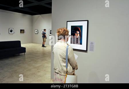 Une femme étudie la photographie afghane Girl de Steve McCurry dans l'exposition Power of Photography au Bowers Museum, Santa Ana, Californie, États-Unis Banque D'Images