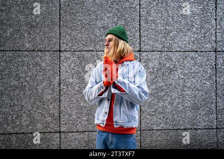 Pensive scandinave slim Guy hipster avec de longs cheveux blonds, personne lgbt attendant la réunion d'un ami Banque D'Images