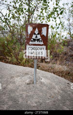 Des panneaux d'avertissement avec des poteaux plantés dans le sable près d'une usine chimique à Parme alertent des dangers potentiels Banque D'Images