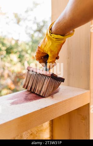 Personne vernissant le bois de la pièce de construction de maison Banque D'Images