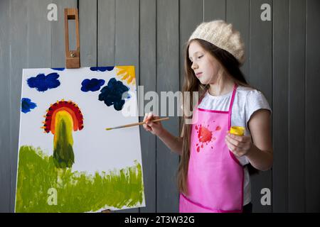 Portrait mignon fille peignant chevalet avec pinceau Banque D'Images