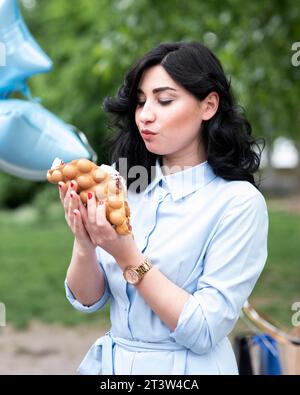 Jeune femme mangeant de la gaufre à bulles Banque D'Images