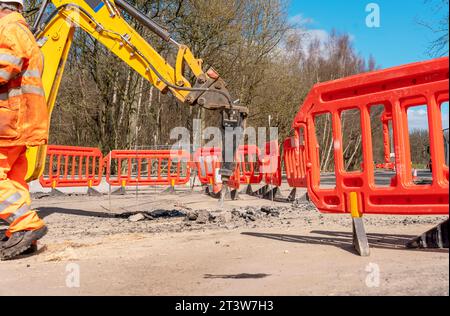Excavatrice cassant et forant le béton et la surface de la route. Grand marteau hydraulique monté sur le bras d'une excavatrice gros plan et mise au point sélective Banque D'Images