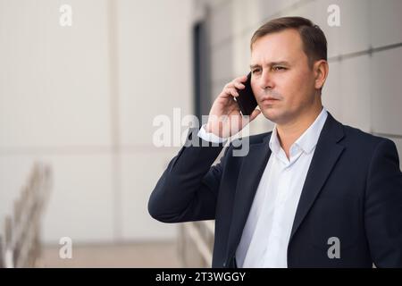 Homme d'affaires confiant en costume parle préoccupé au téléphone Banque D'Images