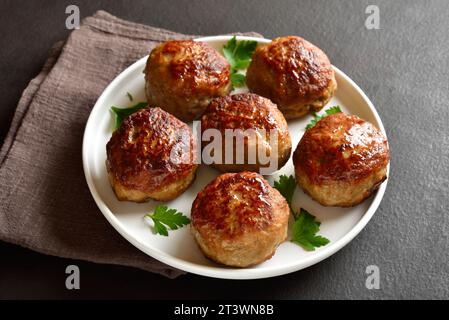 Côtelettes maison de viande hachée sur l'assiette sur fond sombre. Gros plan Banque D'Images