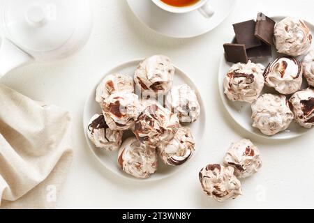 Biscuits meringue au chocolat sur fond blanc. Vue de dessus, pose à plat Banque D'Images