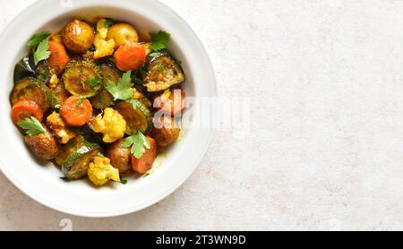 Vue rapprochée de légumes cuits dans un bol sur fond clair avec espace de copie. Végétarien végétalien ou concept d'alimentation saine. Vue de dessus, pose à plat Banque D'Images