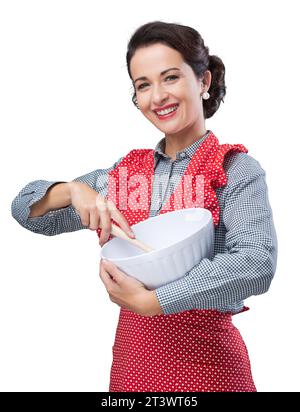 Vintage femme cuire le mélange des ingrédients dans un bol et souriant Banque D'Images