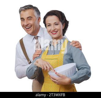 Vintage couple amoureux à la maison, elle porte un tablier de cuisine et Banque D'Images