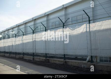 Clôture haute autour de l'usine. Treillis de clôture. Obstacle en acier. Banque D'Images