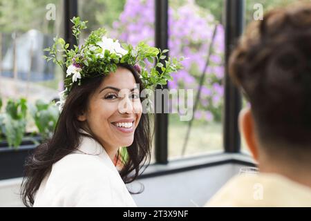 Portrait de femme souriante portant la tiare de fleur au patio Banque D'Images