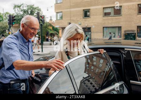 Couple senior entrant dans le taxi en ville Banque D'Images