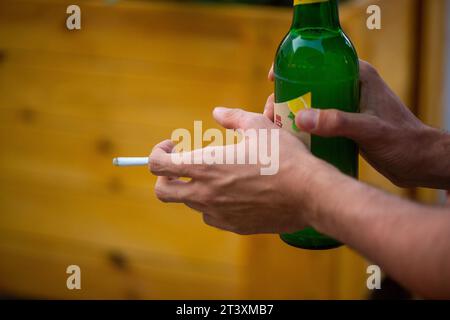 Berlin, Allemagne. 10 juillet 2023. Un homme tient une cigarette allumée et une bouteille de bière Radler dans ses mains. Crédit : Fernando Gutierrez-Juarez/dpa/Alamy Live News Banque D'Images